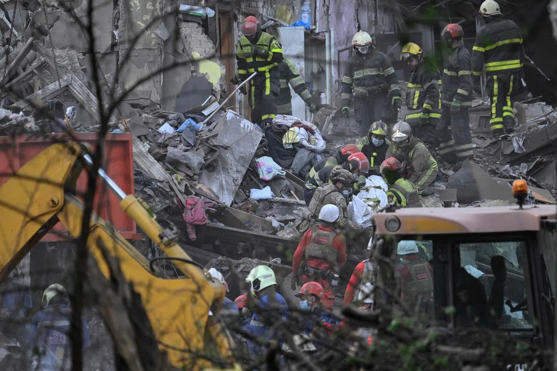 Ukrainian rescuers carrying the body of a victim at the site of a Russian missile strike in Kyiv, on April 24.