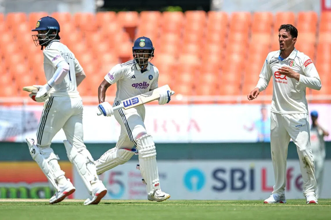 India's Sai Sudharsan (centre) and K.L. Rahul run between the wickets as Afghanistan's Ziaur Rahman watches during the first day of their only Test cricket match at the Maharaja Yadavindra Singh International Cricket Stadium on the outskirts of Chandigarh on June 6, 2026.