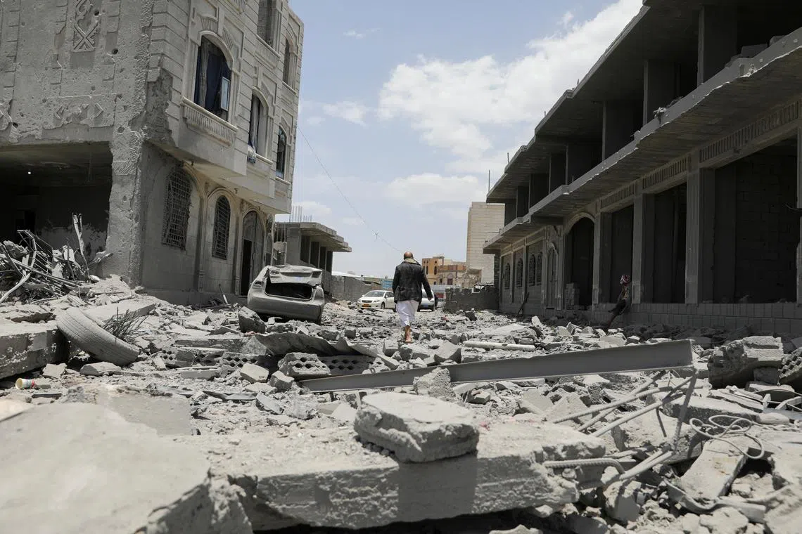 A man walks on the rubble of a building destroyed by U.S. air strikes in Sanaa, Yemen April 27, 2025. REUTERS/Khaled Abdullah