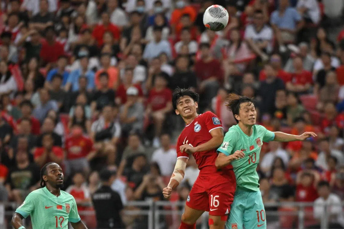 Singapore's Glenn Kweh tussling with China's Xie Pengfei during a World Cup qualifier at the National Stadium on March 21. The match ended 2-2.