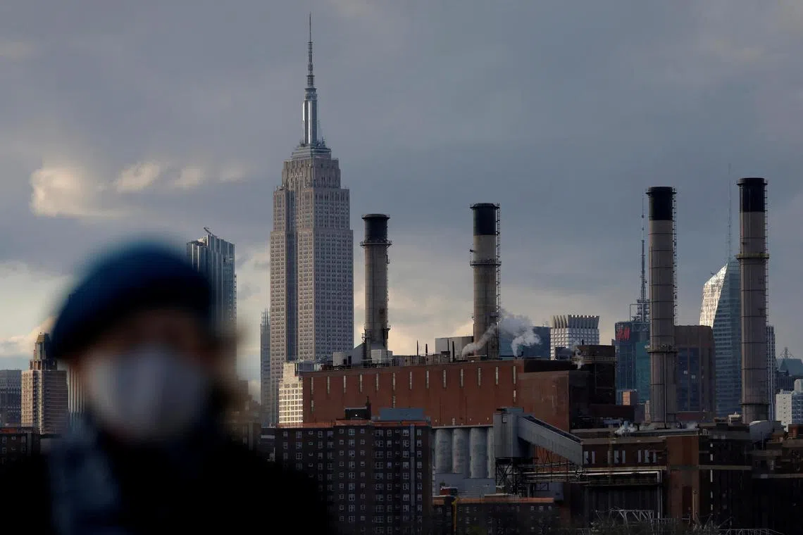 FILE PHOTO: A person walks in front of the Con Edison Power Plant in Manhattan, New York City, New York, U.S., April 22, 2021. REUTERS/Andrew Kelly/File Photo