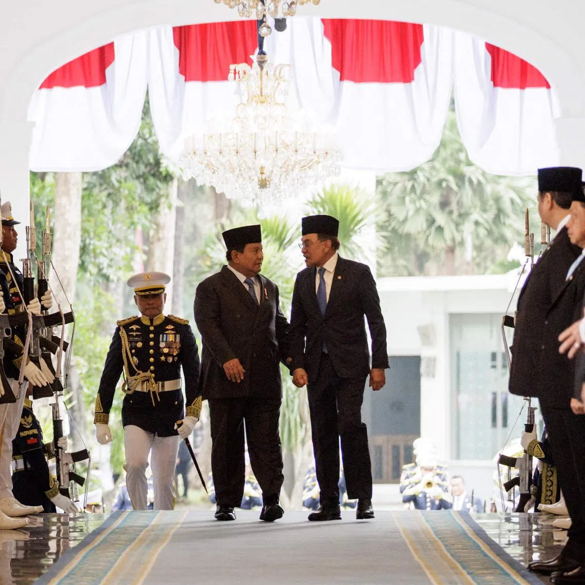 Malaysia's Prime Minister Anwar Ibrahim (right) and Indonesias President Prabowo Subianto walk together ahead of their bilateral meeting at the Presidential Palace in Jakarta, on July 29.
