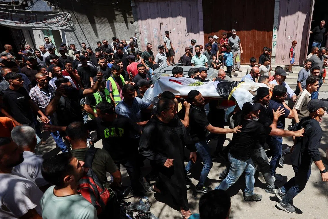 Mourners carry the body of Palestinian man Mohammad al-Waheidi, who worked for the Egyptian Relief Committee and was killed in an Israeli strike on Tuesday, during his funeral, in Gaza City, July 8, 2026. REUTERS/Dawoud Abu Alkas
