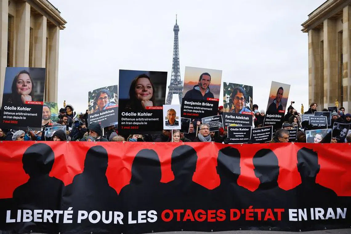 Supporters and relatives of French citizens detained in Iran, Cecile Kohler, Benjamin Briere, Jacques Paris and Fariba Adelkhah, gather in front of the Eiffel Tower, during a rally demanding their release, in Paris, France, January 28, 2023.   REUTERS/Christian Hartmann/File Photo