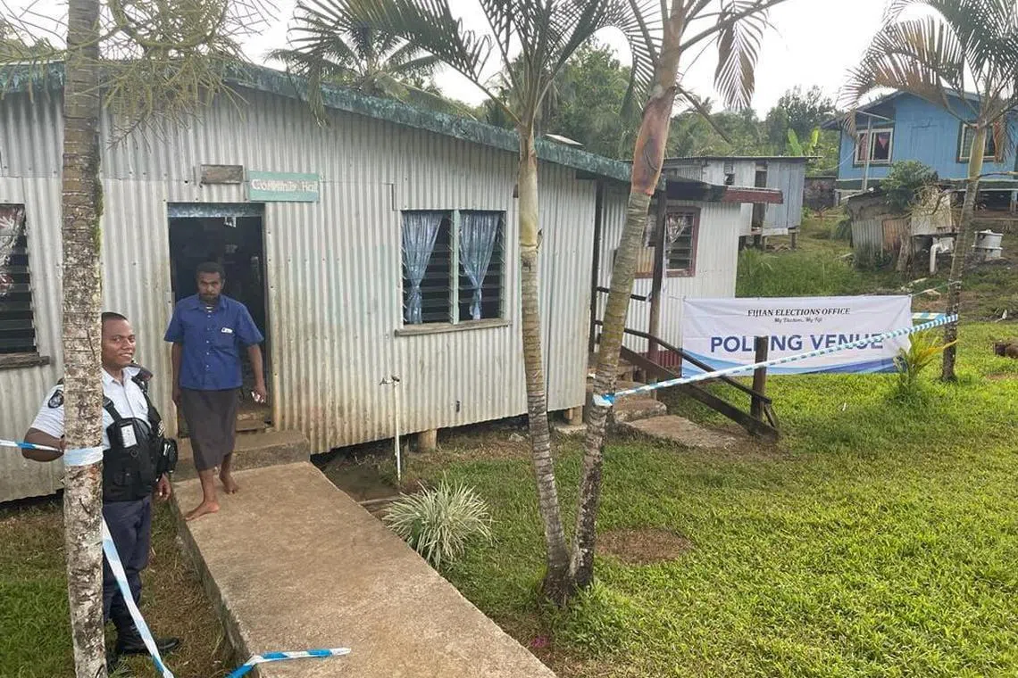 People standing outisde a pollng venue before the general election, in Namara, Fiji, on Dec 7, 2022.