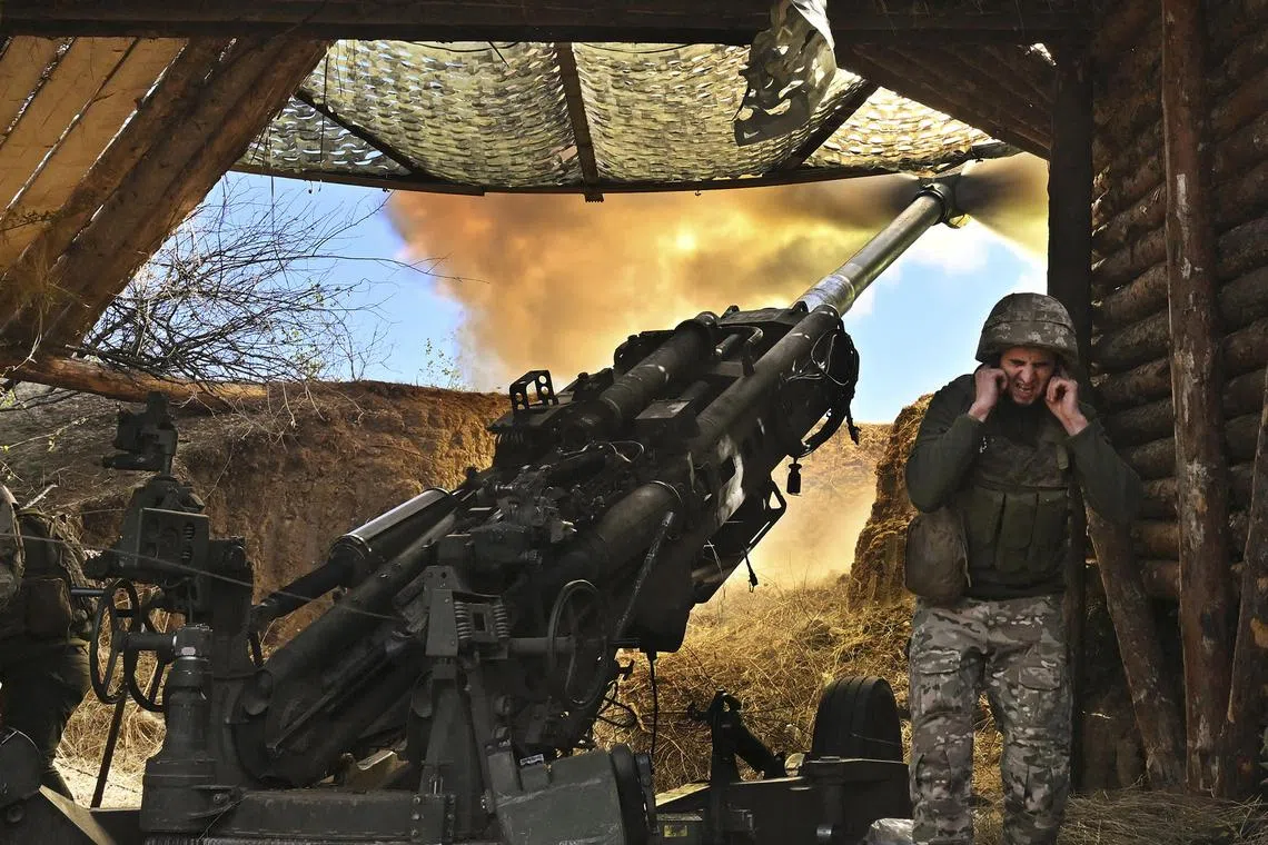 Ukrainian soldiers fire a howitzer towards Russian positions near the front line in the Donbas region of eastern Ukraine.