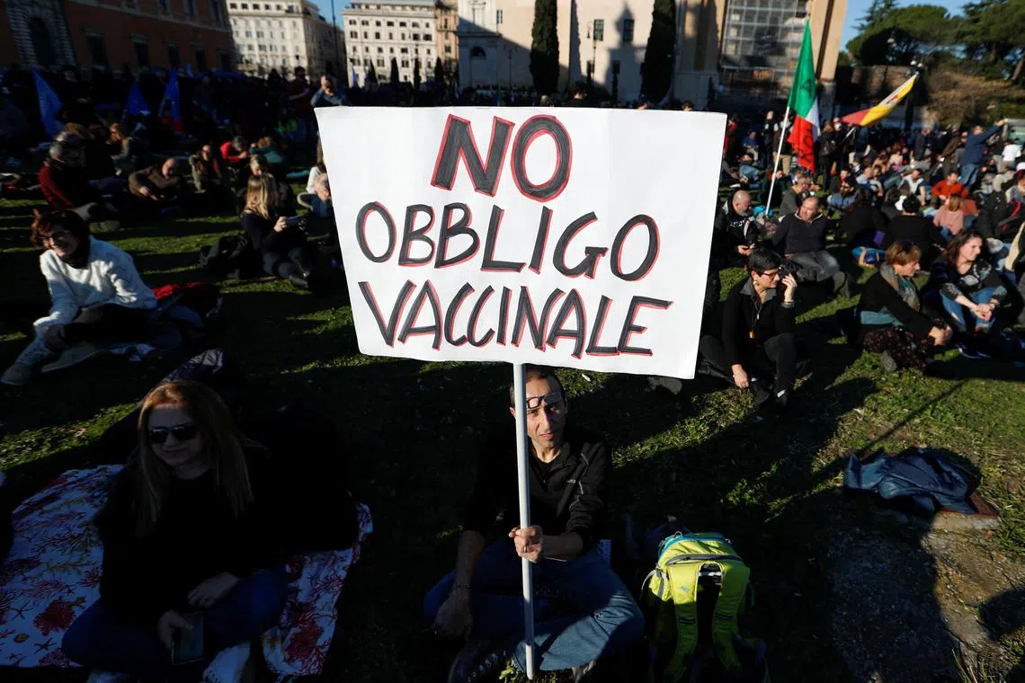 FILE PHOTO: A demonstrator holds a sign during a protest against the Italian government after it made vaccinations against the coronavirus disease (COVID-19) mandatory for people aged 50 years and over, as new cases surge in Rome, Italy, January 15, 2022. The sign reads: 'No vaccination obligation'. REUTERS/Remo Casilli/File Photo
