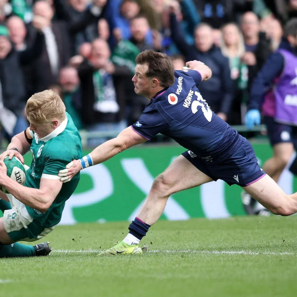 Ireland's wing Tommy O'Brien scores a try despite pressure from Scotland's George Horne in their Six Nations international rugby union match at the Aviva Stadium in Dublin, on March 14, 2026.
