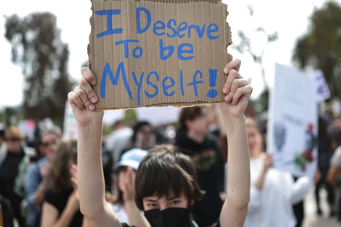 A protester holds a sign at a rally protesting the “anti-democratic and illegal actions of the Trump administration”.
