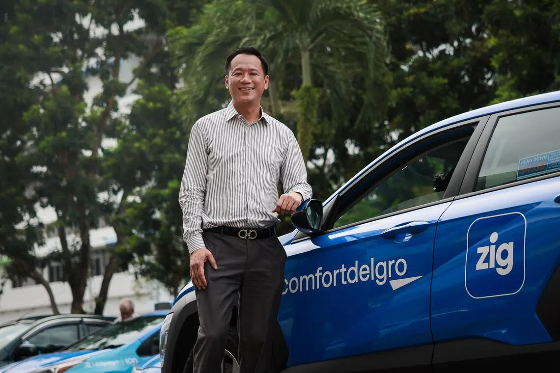 ComfortDelGro's head of point-to-point mobility business in Singapore Michael Huang with the company’s redesigned logo on the side of a taxi at Comfort Transportation at Sin Ming Drive on Sep 22, 2025.