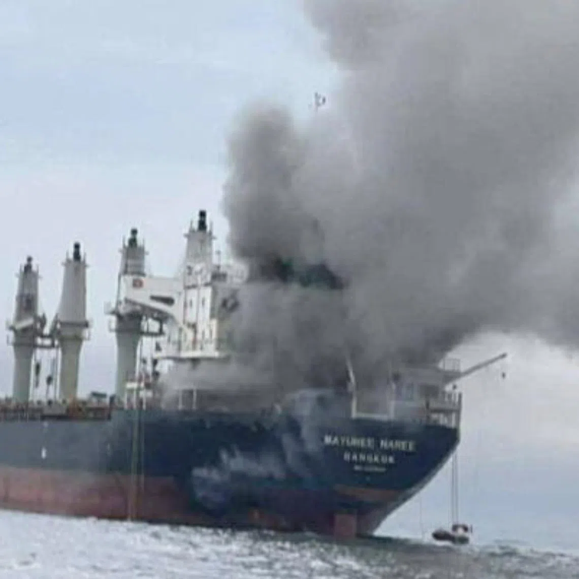 Thailand-flagged cargo ship Mayuree Naree engulfed in black smoke after being hit in the Strait of Hormuz in March. 