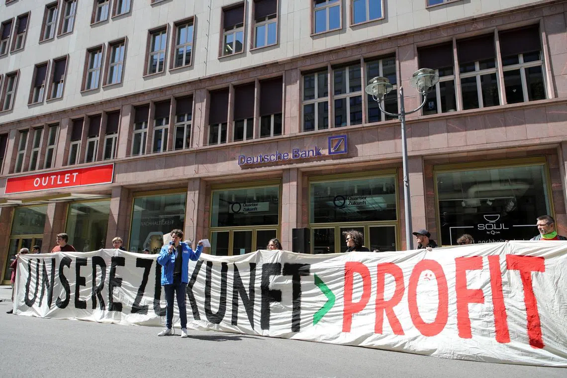 Fridays For Future activists protest against greenwashing by Deutsche Bank in Berlin, Germany, May 17, 2023. Banner reads: "Our future > profit". REUTERS/Nadja Wohlleben