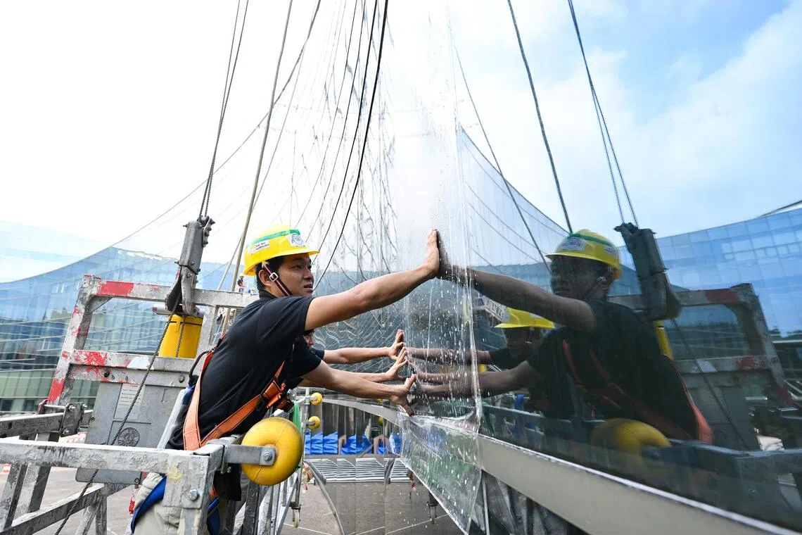 Installers from Jestac installing 3M customised printing film (collision-preventive decals) on the facade of NTU’s School of Art, Design and Media building.