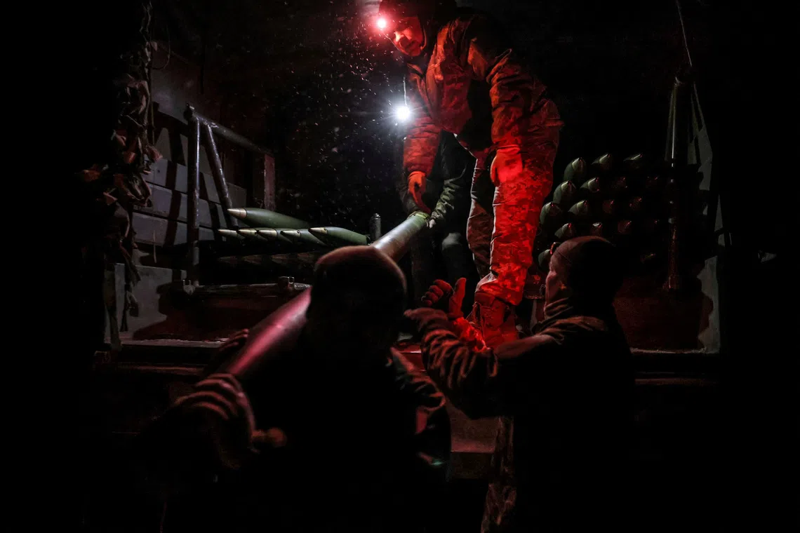 A Ukrainian soldier loads missiles for a BM-21 Grad multiple-launch rocket system as they prepare to fire toward Russian troops, near the town of Chasiv Yar in Donetsk region, Ukraine.