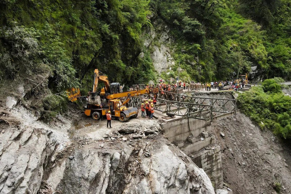 A drone view of Border Roads Organisation (BRO) and State Disaster Response Force (SDRF) officials attempting to build a makeshift bridge to reach Dharali village after the bridge connecting it was swept away during landslides in Gangnani, Uttarakhand, India, August 8, 2025. REUTERS/Francis Mascarenhas      TPX IMAGES OF THE DAY