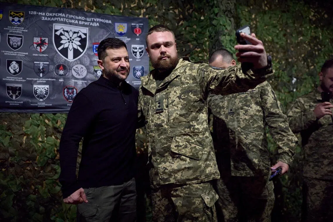 Ukrainian President Volodymyr Zelensky posing for a photo with a Ukrainian serviceman, as he visits the country's Zaporizhzhia region on Nov 13.