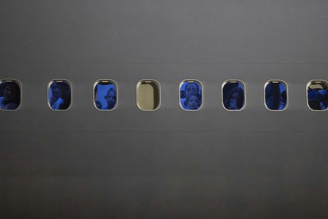 Mexican citizens repatriated from Israel looking out the windows of a Mexican Air Force plane as they land at the Santa Lucia Military Base, in Santa Lucia, Mexico, Oct 11