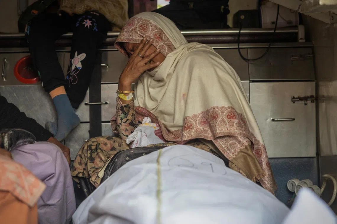 A relative of a stampede victim cries as she sits next to a victim's body inside an ambulance, outside a hospital mortuary, following a stampede that occurred before the second \"Shahi Snan\" (royal bath), at the \"Maha Kumbh Mela\" or the Great Pitcher Festival, in Prayagraj, India January 29, 2025. REUTERS/Adnan Abidi