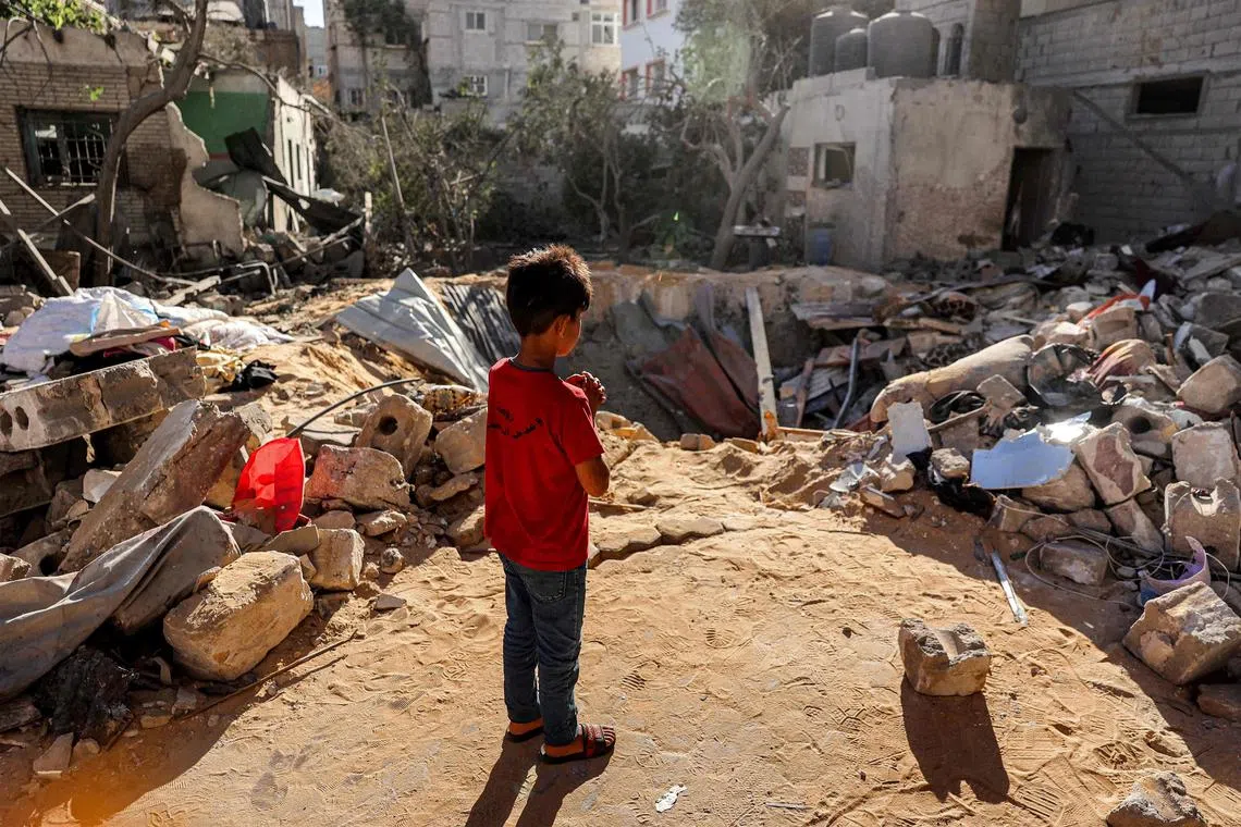 A boy stands before a bomb impact crater  in Rafah, in the southern Gaza Strip. A 2,000-pound bomb, says the UN, can "rupture lungs, burst sinus cavities and tear off limbs hundreds of metres from the blast site."