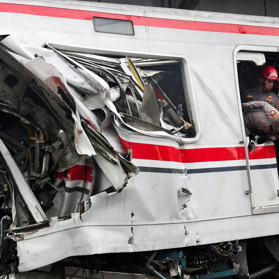 Police officers looking on at the site after a deadly collision between a commuter line train and a long-distance train, in Bekasi, on the outskirts of Jakarta, Indonesia, on April 28, 2026. 