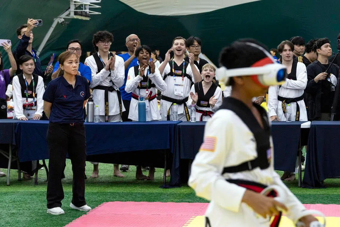 The US team cheering on their teammates during a virtual taekwondo bout at the Chuncheon Korea Open International Taekwondo Championships in South Korea on July 18, 2026. The contactless version of the Korean martial art is making its debut at the Sept 19-Oct 4 Asian Games. Critics say it is a glorified video game.