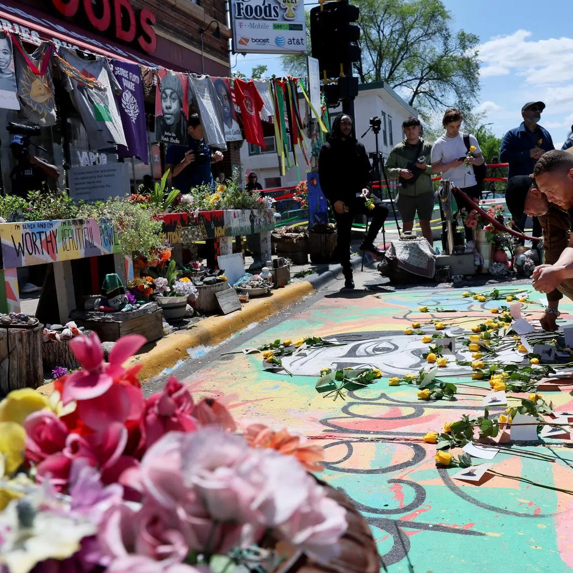 Jazz Hampton lays a rose as he and other community, family and friends pay their respects at the memorial site where George Floyd was murdered by former police officer Derek Chauvin ahead of the fifth anniversary of Floyd’s death in Minneapolis, Minnesota, U.S., May 23, 2025. REUTERS/Leah Millis