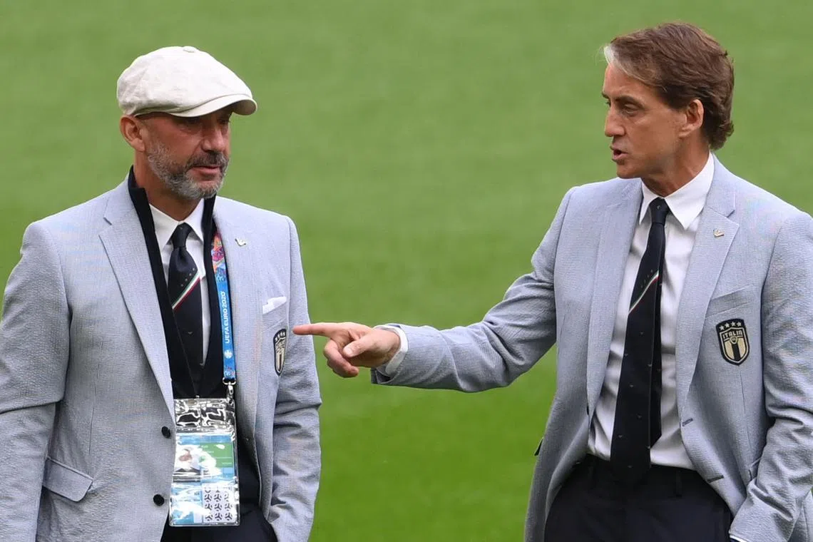 A photo on June 26, 2021 shows Italy coach Roberto Mancini (right) speaking to assistant Gianluca Vialli, who has since died following a long battle with cancer.