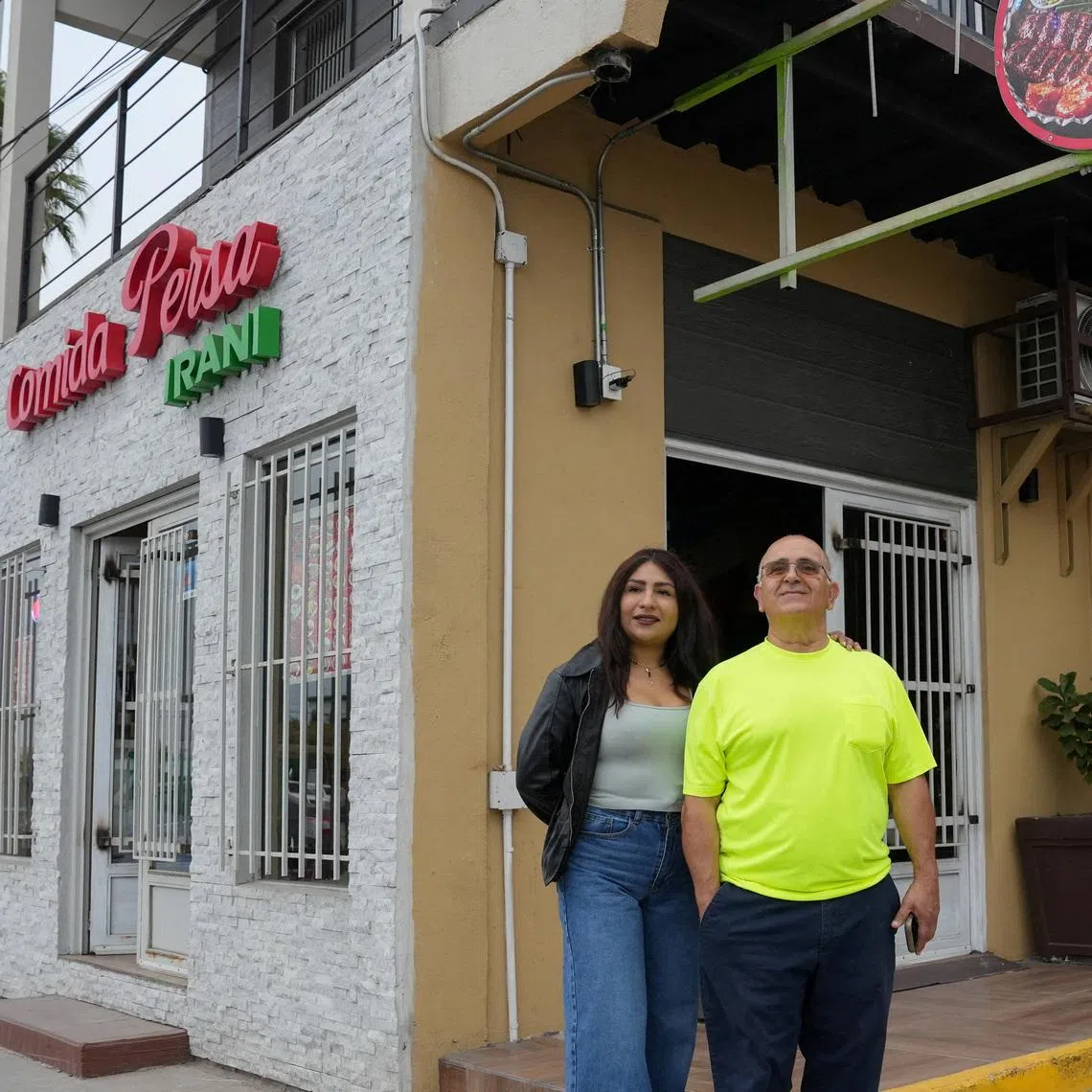 Iranian Saied Assadi, owner of the Comida Persa Iran restaurant, and his Mexican partner Claudia Leonardo pose outside the venue in Rosarito, on the outskirts of Tijuana, where a small Iranian community reflects broader political divisions within the diaspora ahead of the team’s World Cup campaign, in Rosarito, Mexico, June 10, 2026. REUTERS/Aimee Melo