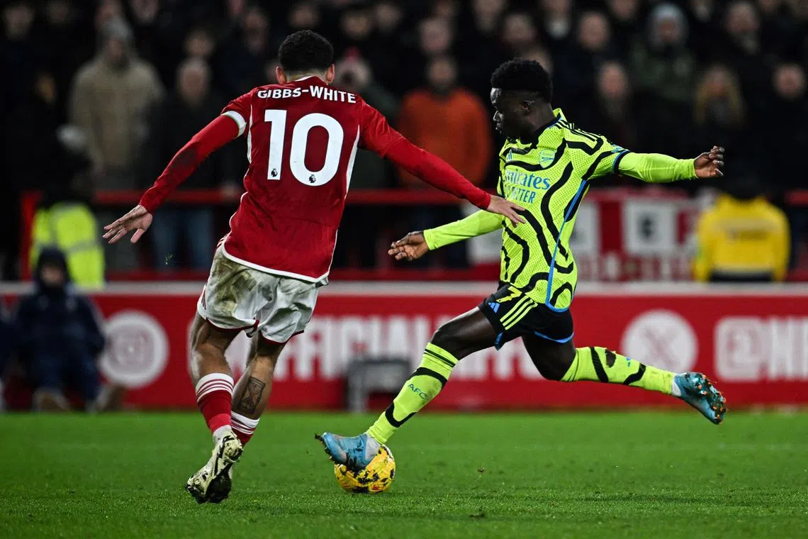 Arsenal's Bukayo Saka (right) shoots and scores his team's second goal.