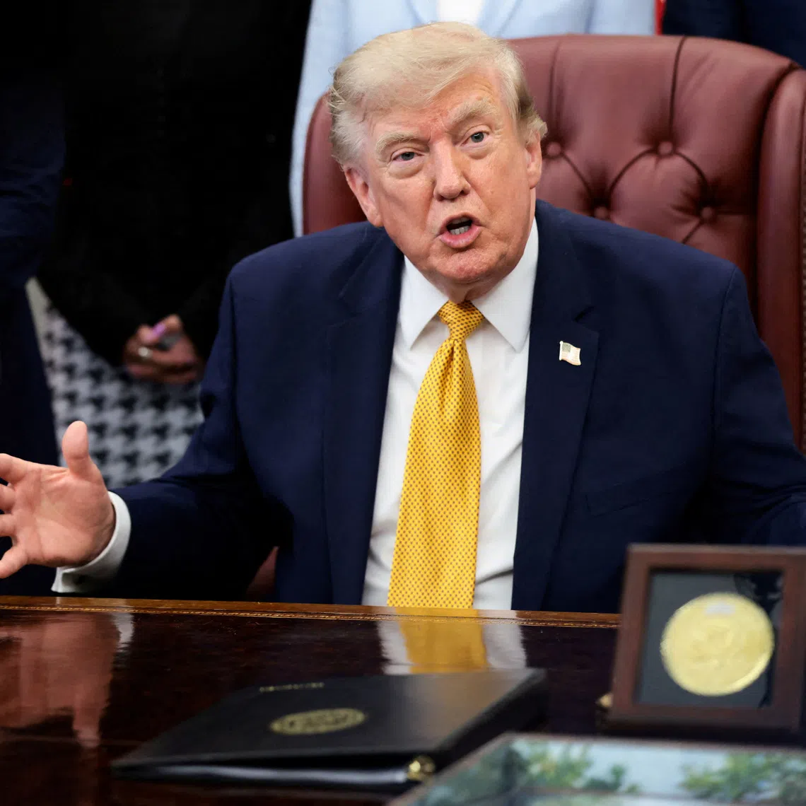 FILE PHOTO: U.S. President Donald Trump answers questions from the media after signing an executive order, in the Oval Office at the White House in Washington, D.C., U.S., August 3, 2026. REUTERS/Evelyn Hockstein/File Photo