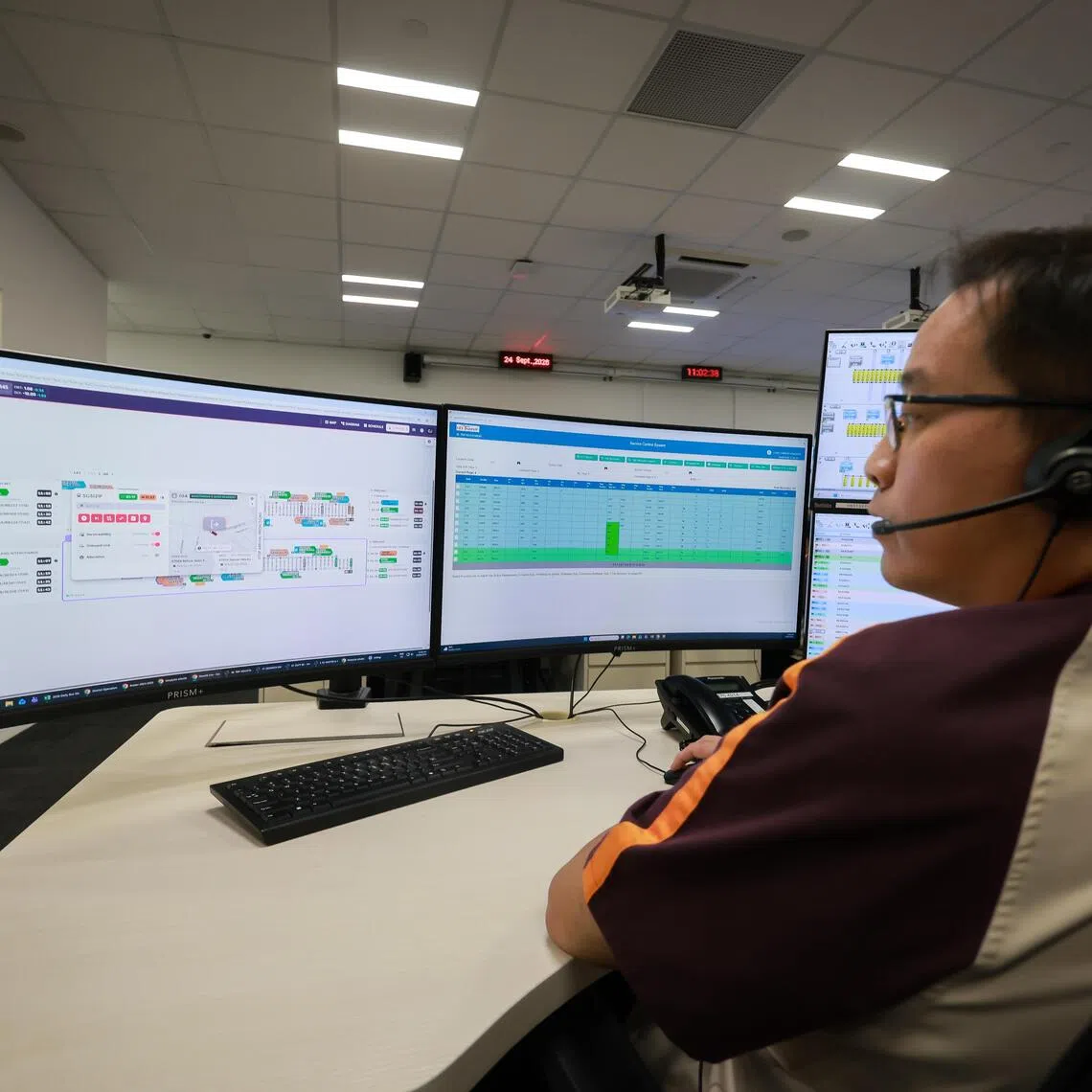 SBS Transit senior service controller Calvin Chan scanning recommendations made by AI at Seletar Bus Depot.