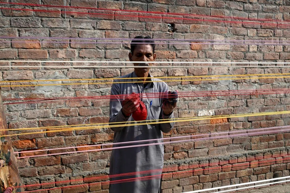 A man applying coats of glass powder to kite strings ahead of the Basant Festival in Lahore, on Jan 18, 2026.