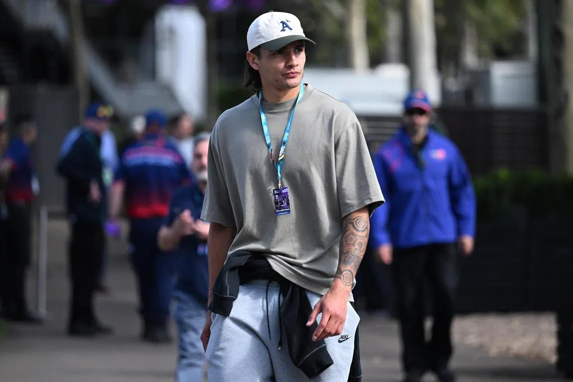Western Bulldogs player Jamarra Ugle-Hagan, seen here at the Formula One Australian Grand Prix, raised his jersey and pointed to his skin in a show of defiance after saying he was abused from the stands against St Kilda in an Australian Rules game.