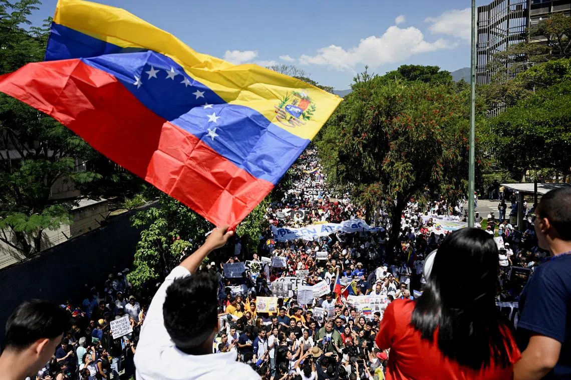 FILE PHOTO: A man waves a Venezuelan flag as university students and relatives of detainees mark Youth Day with a march calling for amnesty for political prisoners, highlighting continued demands for political reforms in the country, in Caracas, Venezuela, February 12, 2026. REUTERS/Maxwell Briceno/ File Photo