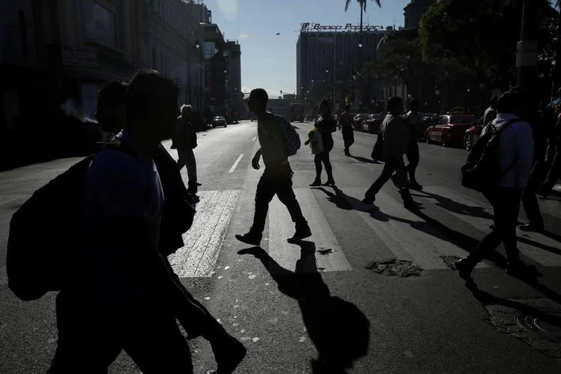People cross the street, one day after Costa Ricans elected Carlos Alvarado Quesada, as the new president, in San Jose, Costa Rica April 2, 2018. REUTERS/Juan Carlos Ulate/File Photo