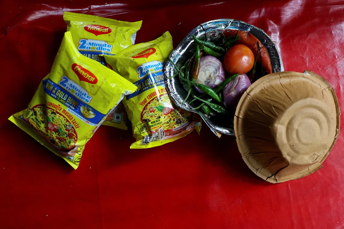 Packets of Nestle Maggi 2-Minute Noodles lie next to vegetables on a table, at a roadside food stall in New Delhi, India, August 20, 2026. REUTERS/Anushree Fadnavis