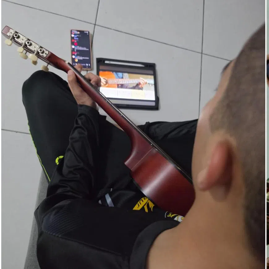 Ryan Zafran Shahrin practises the guitar using YouTube lessons and guidance from friends on a Discord guitar channel at his home in Puncak Alam, Selangor on June 9.