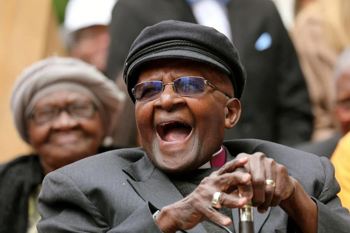 Archbishop Desmond Tutu laughs as crowds gather to celebrate his birthday by unveiling an arch in his honour outside St George's Cathedral in Cape Town, South Africa, October 7, 2017. REUTERS/Mike Hutchings/File Photo