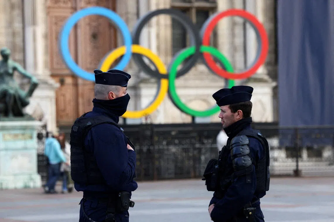 FILE PHOTO: French police officers stand guard near the Olympic rings which are displayed for the Paris 2024 Summer Games in Paris, France, March 21, 2023. REUTER/Yves Herman/File Photo