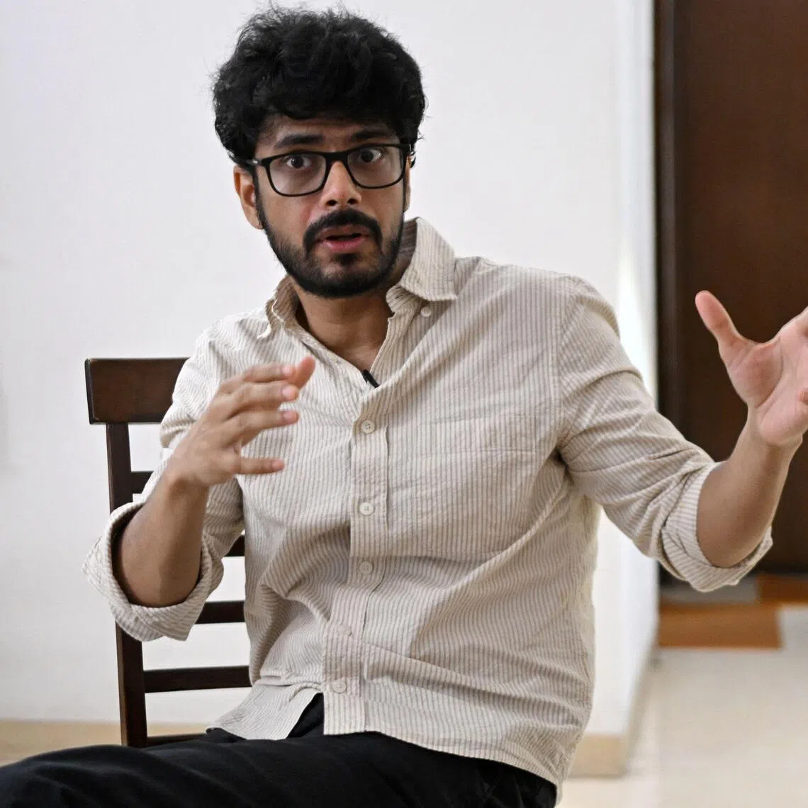 This photograph taken on August 12, 2026 shows Oscar-nominated Indian filmmaker Shaunak Sen speaking during a interview with AFP at his residence in New Delhi. Sen's new documentary "All That Breathes", began as a "coping" mechanism after a shock cancer diagnosis, but continues the motifs of environmental degradation and caregiving that drove his previous work. (Photo by Arun SANKAR / AFP)