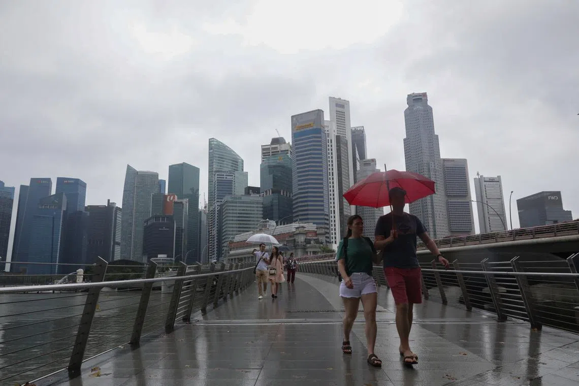 ST20230125_202303344726/pixgeneric/Ryan Chiong Generic pictures of people against the Singapore city skyline in the rain at the Jubilee Bridge on Jan 25, 2023. Can be used for stories about rain, wet weather, tourists, foreigners, Singapore.