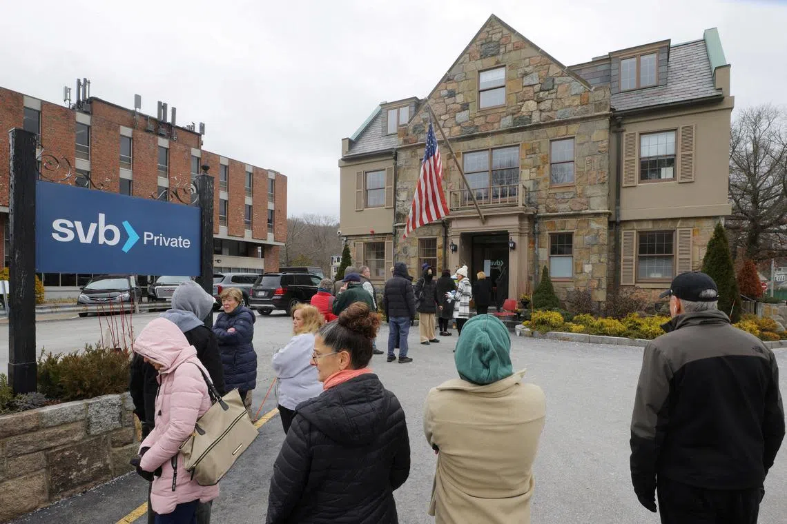 Customers wait in line outside a branch of the Silicon Valley Bank in  Massachusetts, US, on March 13, 2023.  