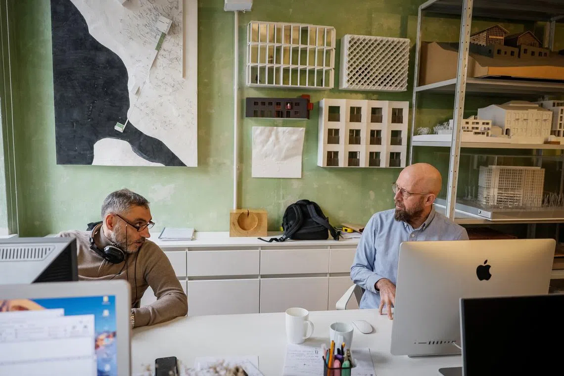 Oleh Drozdov, an architect from Kharkiv, and his business partner talk in their reopened office, amid Russia's attack on Ukraine, in Lviv, Ukraine, March 11, 2024. REUTERS/Alina Smutko