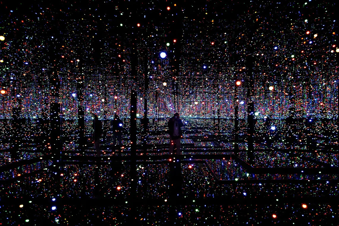 FILE PHOTO: A photographer takes pictures of an installation titled \"Infinity Mirrored Room - Filled With the Brilliance of Life\" by Japanese artist Yayoi Kusama during her exhibition at the Rufino Tamayo museum in Mexico City, Mexico, October 6, 2014.   REUTERS/Tomas Bravo/File Photo