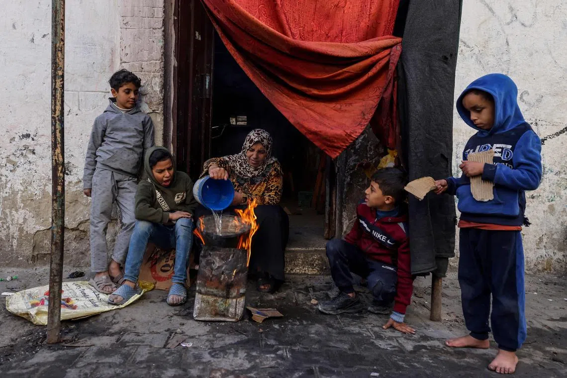 A Palestinian woman makes food outside a house in the southern Gaza Strip.