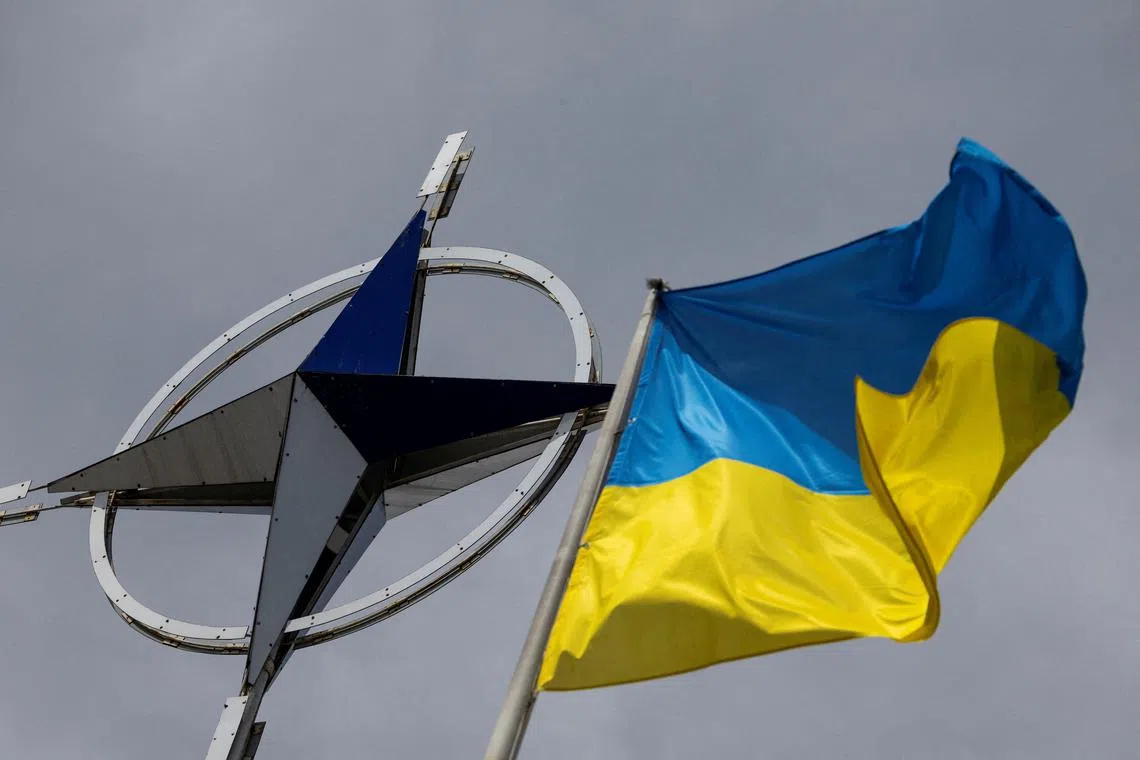 FILE PHOTO: A Ukrainian national flag is pictured in front of the NATO emblem, amid Russia's attack on Ukraine, in central Kyiv, Ukraine July 11, 2023. REUTERS/Valentyn Ogirenko/File Photo