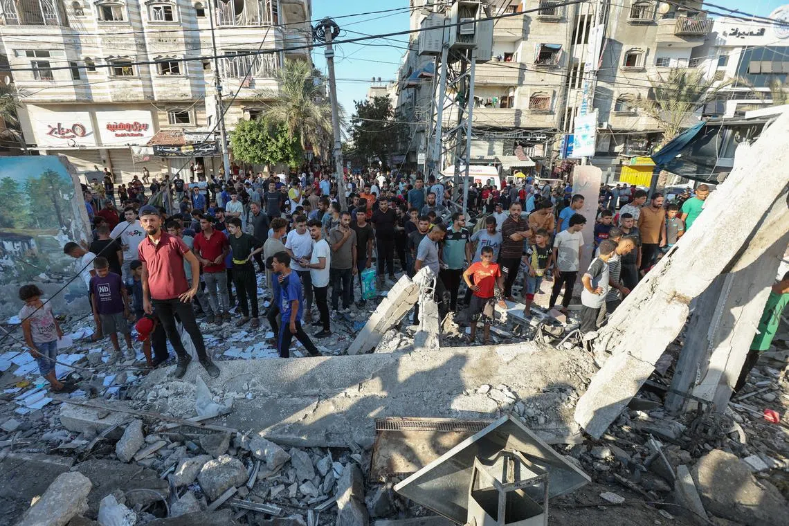 Palestinians gather at the site of an Israeli air strike on a UN school sheltering displaced people, in al-Nusairat, in the central Gaza Strip. 