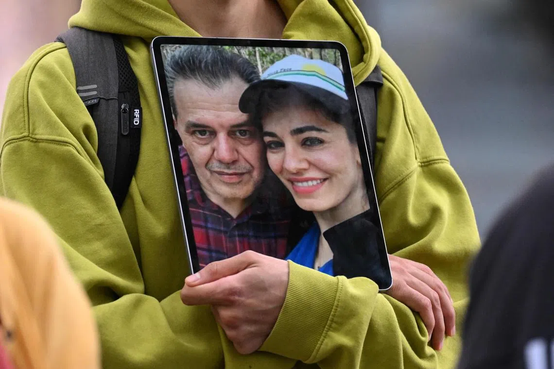 A 2023 photo shows a demonstrator holding a photo of Iranian-German Jamshid Sharmahd (left), with his daughter Gazelle Sharmahd.