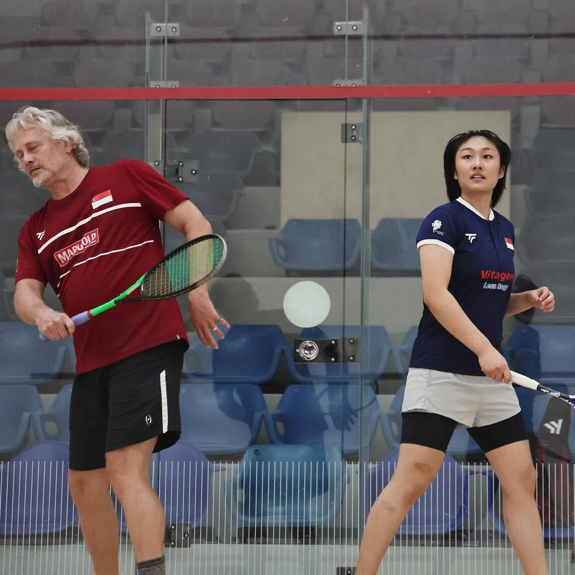 Cassandra Ong (right) practicing with then-national head coach Jamie Hickox at the Kallang Squash Centre ahead of the 2024 Singapore Squash Open.