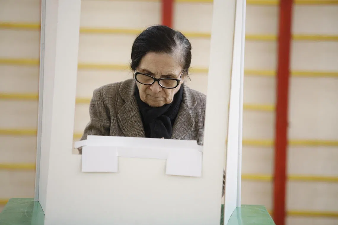 A Georgian woman casting her ballot during parliamentary elections, at a polling station in Tbilisi, Georgia, on Oct 26.